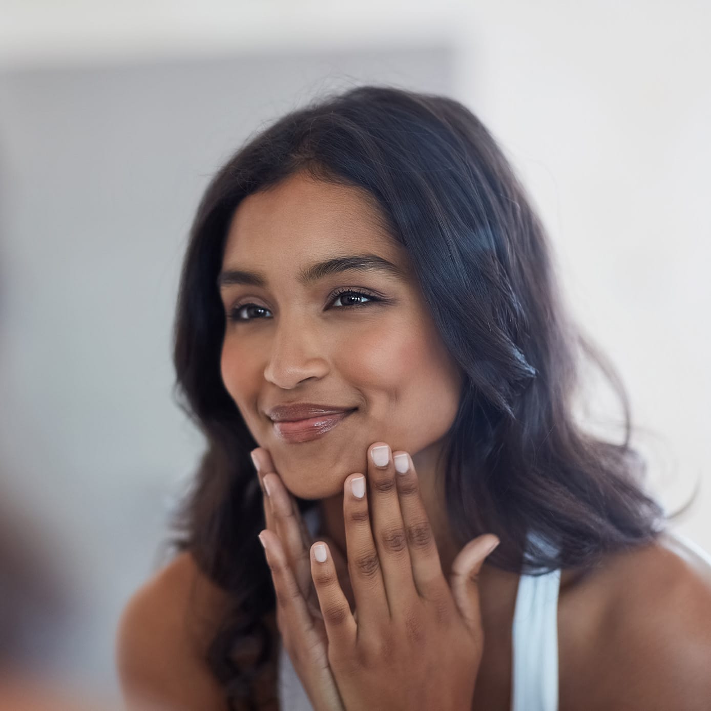 woman touching her face and smirking